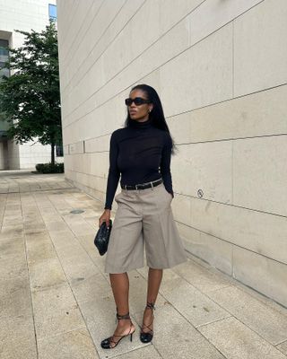 Elegant Autumn Outfits: @nlmarilyn wears a pair of tailored-knee length trousers in beige and a black roll neck top