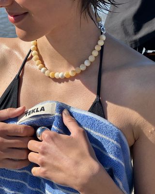 Woman wearing stone necklace.