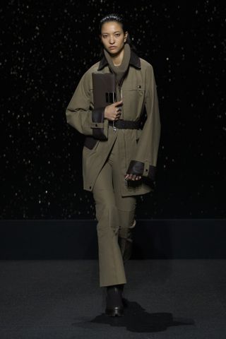 Head to toe khaki outfit with straight pants and a belted barn jacket at the Hermes show.