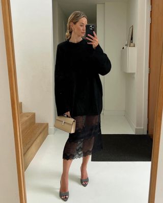 Anouk Yve in a black knit and lace sheer skirt.