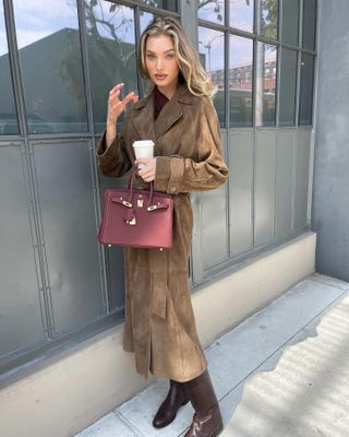 Elsa Hosk wearing a brown suede coat and burgundy Hermès bag