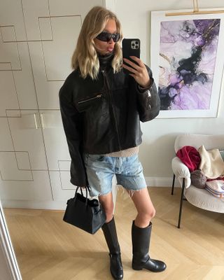 Elsa Hosk wearing a leather jacket, denim shorts, and boots