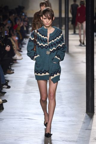 Woman in Fair Isle cardigan on runway.