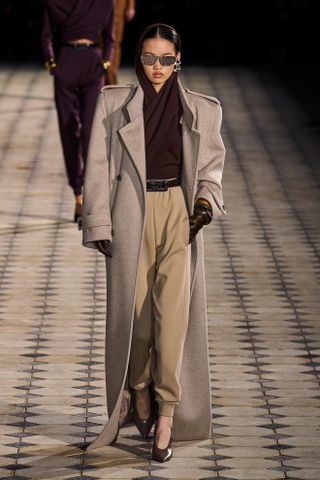 Saint Laurent model walks the spring/summer 2023 runway wearing a maxi coat