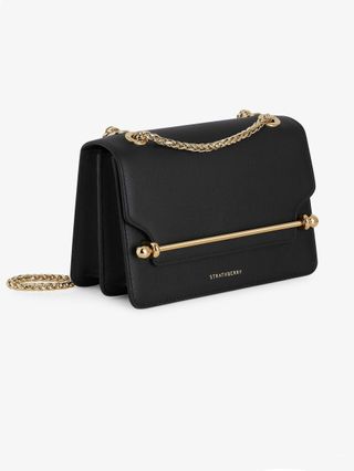 a rectangular purse with gold hardware and a flap opening 