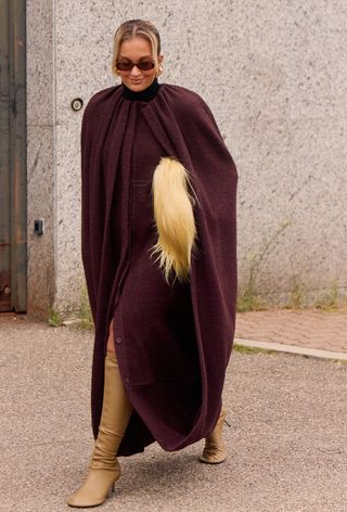 A woman wearing the wine red color trend during Milan Fashion Week spring/summer 2025.