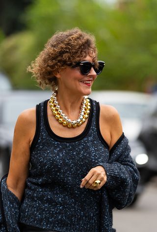 A woman wearing oversize jewelry during Milan Fashion Week spring/summer 2025.