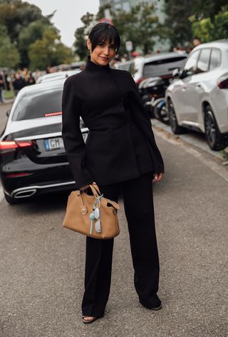 A woman wearing the bag charm trend during Milan Fashion Week spring/summer 2025.