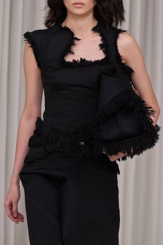 Ferragamo model wearing black feathered bag