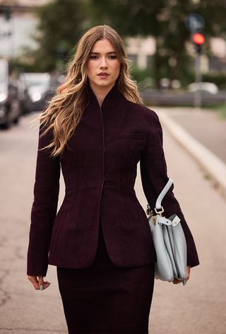 Milan Fashion Week spring 2025 street style photo of a woman wearing the wine red colour trend