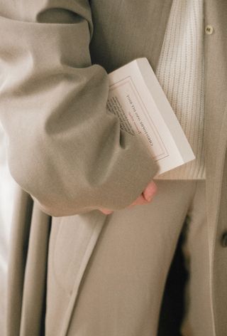 Person holding book under their arm