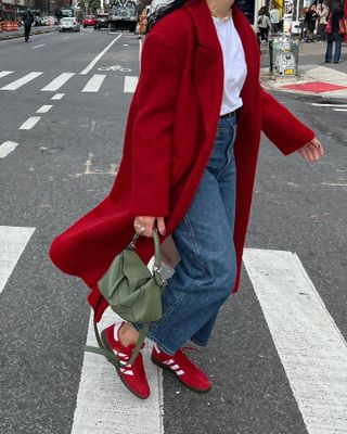 Influencer wears red suede trainers.