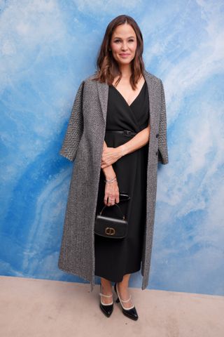 Jennifer Garner wears a gray long jacket, black maxi dress, dior black bag, and black pumps.