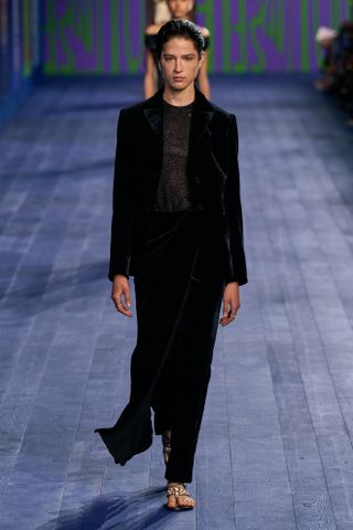 Model wears a velvet suit on the Dior runway.