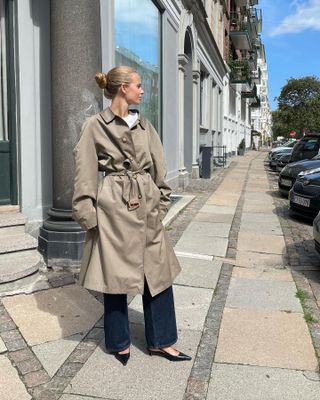 woman in trench, jeans, and pointed heels