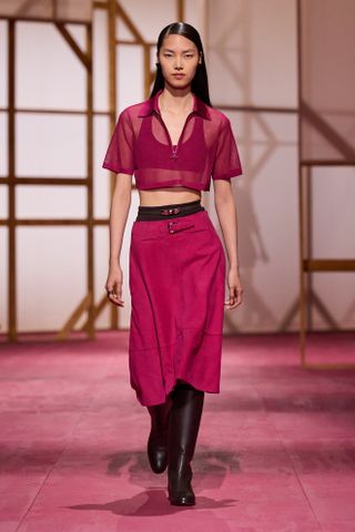 an Hermes model walks the spring/summer 2025 runway in a fuchsia pink look