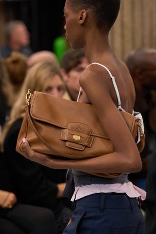 A close-up image of a brown shoulder bag at the Miu Miu spring summer 2025 runway show in Paris.