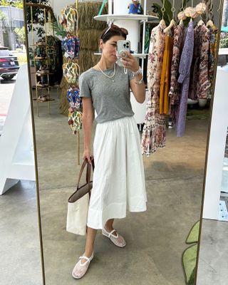 Fashion editor, Judith Jones, wearing gray t-shirt, white skirt, and mesh ballet flats