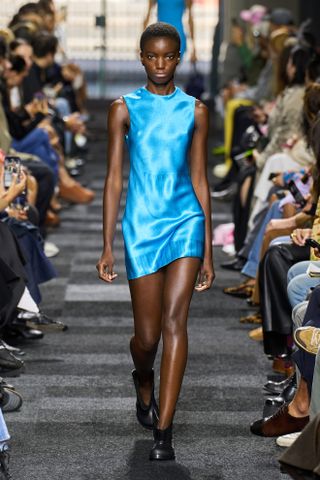 A JW Anderson model walking in the Spring Summer 2025 show wearing an electric blue minidress.