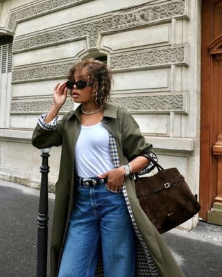 Woman in olive green jacket and brown bag.