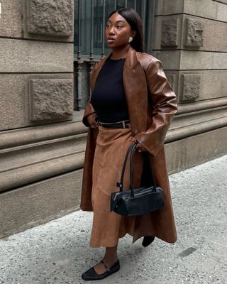 Best Suede Skirts: @nnennaechem wears a tan suede flared skirt with a tan leather coat and black accessories