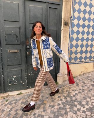 a woman wears a blue and white quilted jacket