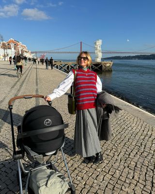 a woman wears a red striped sweater vest