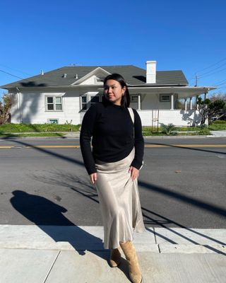 Influencer wears a skirt and boots.