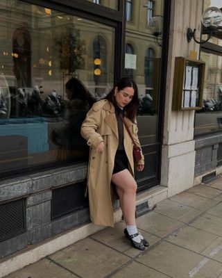 Influencer wears a miniskirt and coat.