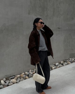 Elegant Jumper Outfits:  @dawn.tan wears a grey jumper with suede jacket and navy wide-leg trousers