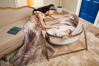 Stylish woman looking at her baby in a bassinet