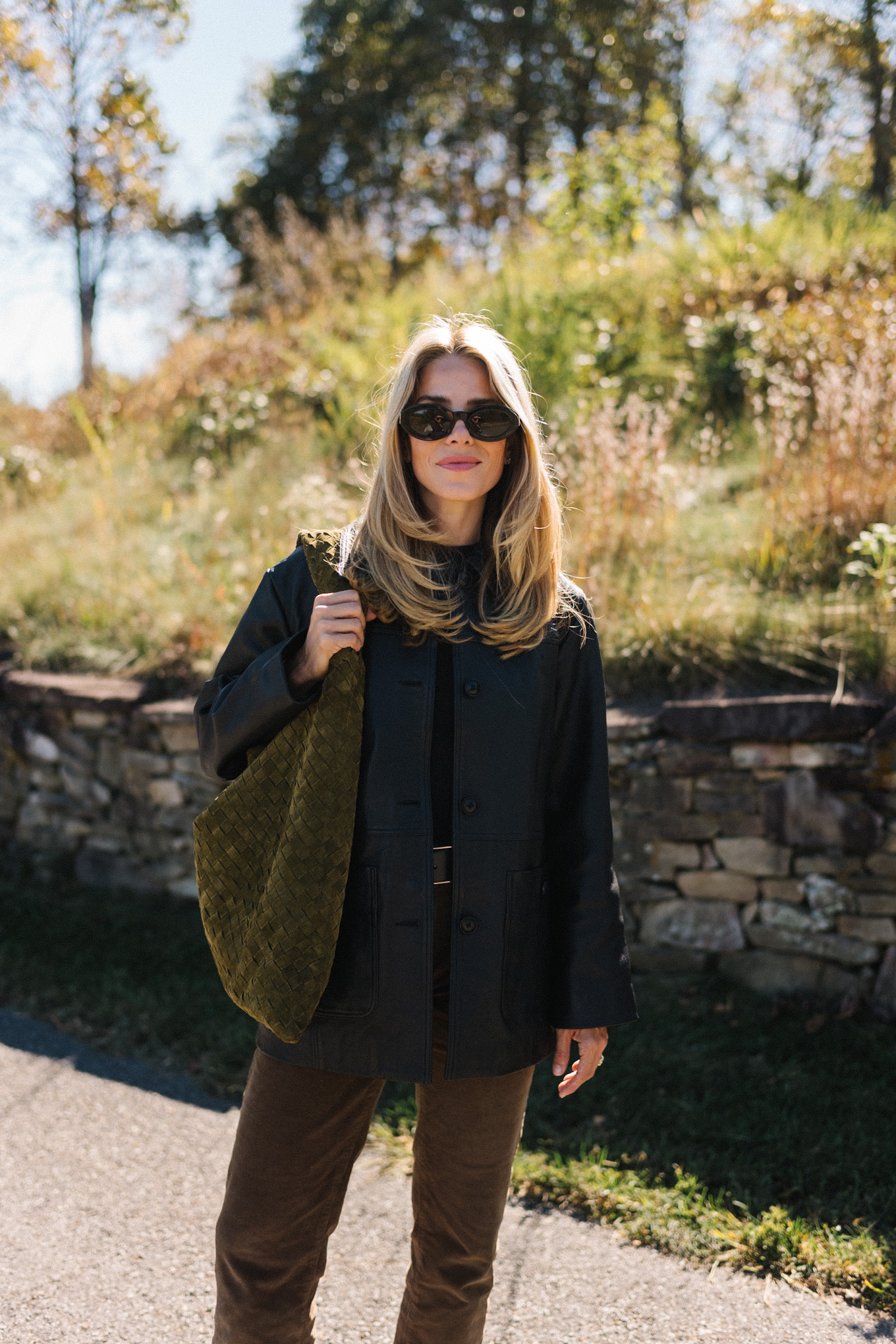 black leather jacket black sweater corduroy pants suede bag