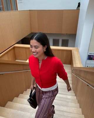 Influencer wears a red cardigan.