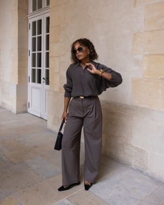 Influencer wearing a polo sweater, pleated pants, and pointed-toe flats