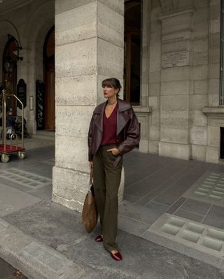 Woman in burgundy top and dark green pants.