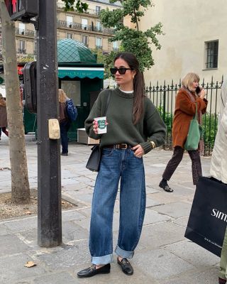 Woman in green sweater and jeans.