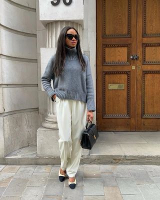 @symphonyofsilk wears a pair of cream satin trousers with a grey jumper