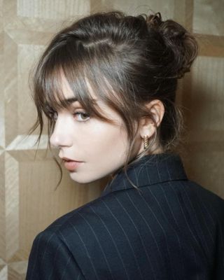 Lily Collins with French bun hairstyle and fringe