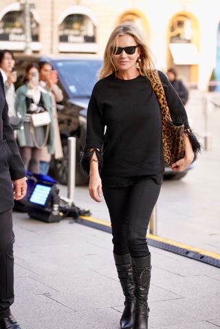 Kate Moss outside of the Ritz Paris wearing an all black outfit with a leopard print Saint Laurent Bea bag.