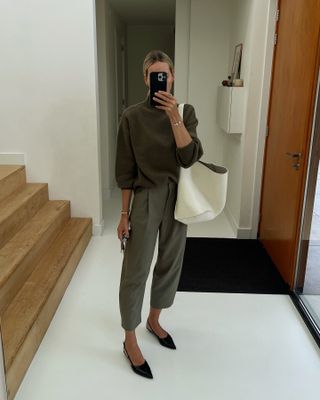 Fashion influencer Anouk Yve wearing an on-trend fall/winter 2024 outfit styled with a chic sweater.