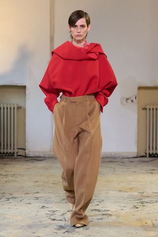 Carven F24 a model wears a red top with tan trousers.