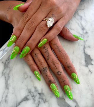 Neon green nails with gold detailing by Los Angeles-based celebrity nail artist Zola Ganzorigt