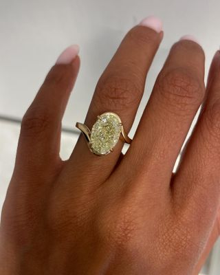 Woman wearing yellow oval AARYAH engagement ring.