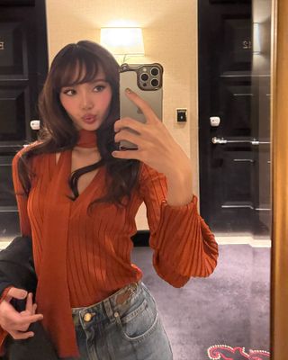 Lisa taking a mirror selfie showing off her side bangs