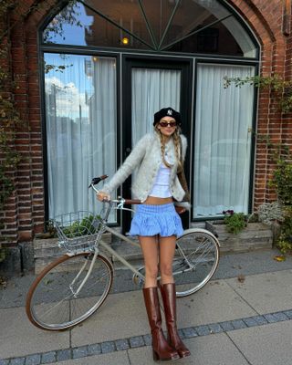 Anna Winck in a cardigan, white T-shirt, and mini bubble hem skirt.