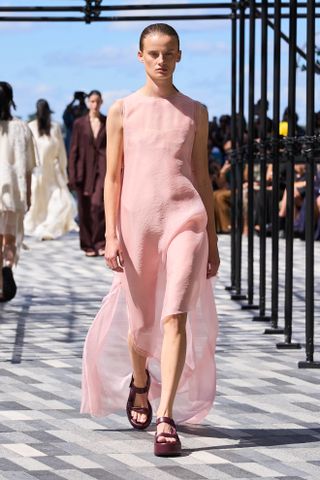 Model wears powder pink on the runway