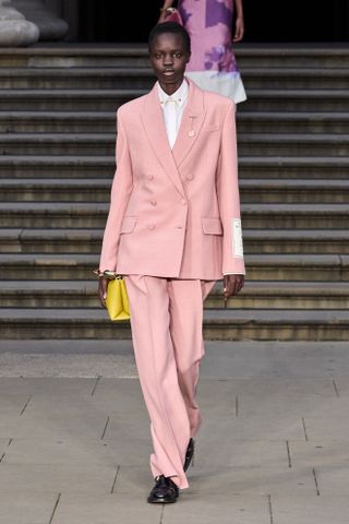 Model wears powder pink on the runway