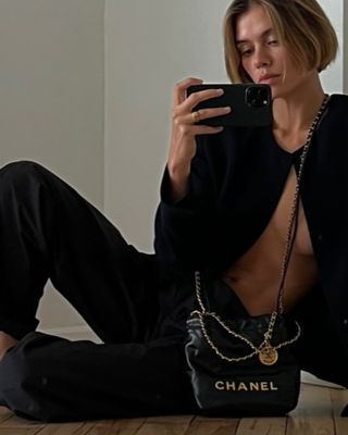 Woman holding a Chanel 22 mini bag.