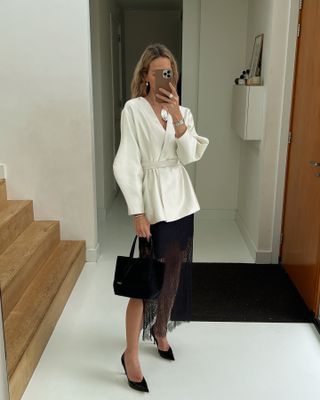 Lace skirt outfits: @anoukyve wears a silk blouse with a lace skirt and court shoes