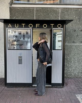 Woman wears black top, grey jeans and black boots